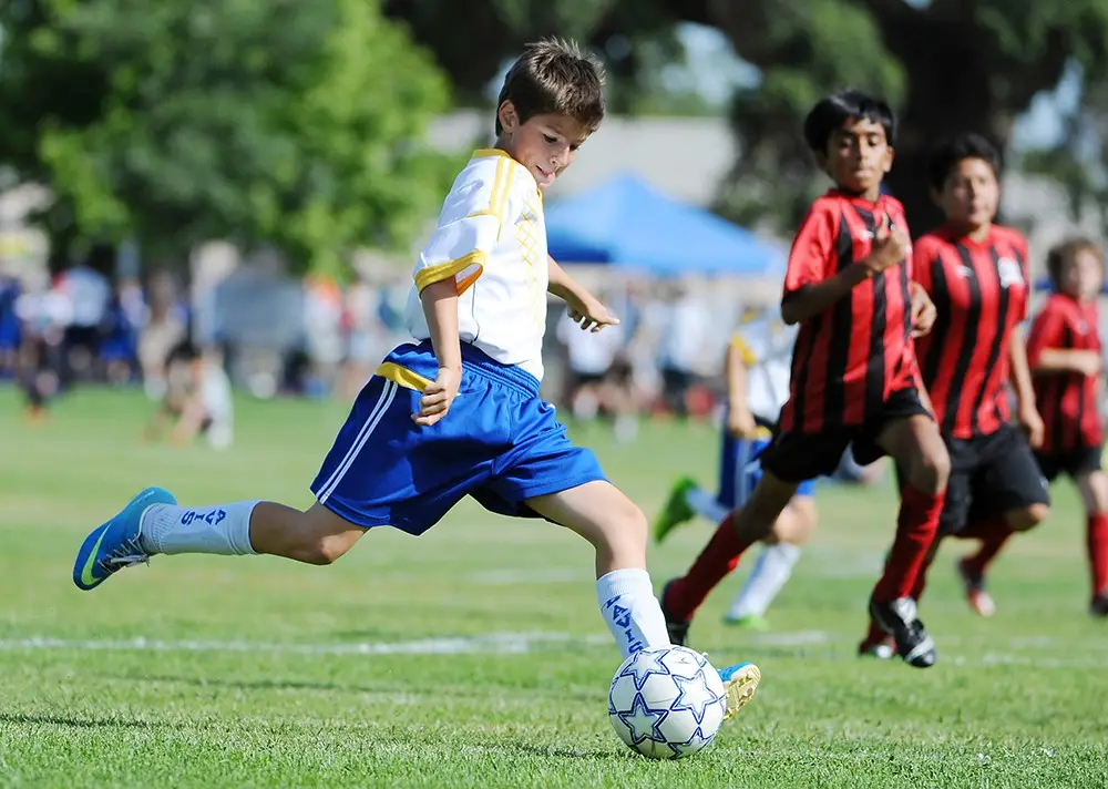 Young player striking the ball during a youth soccer game